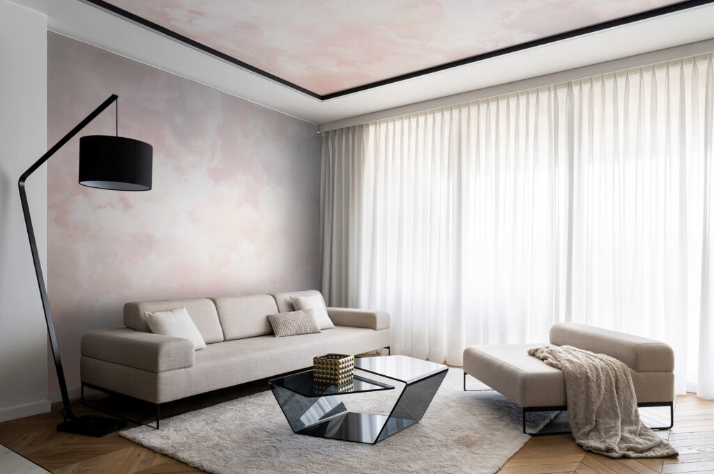 Pink clouds and sky view wallpaper set on a living room accent wall and the ceiling. Baubauwall Wallpapers