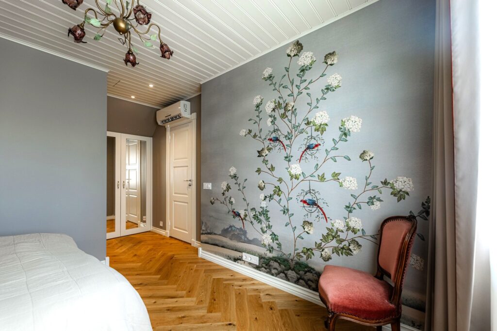 Bedroom wallpaper set on an accent wall. The wall mural is decorated with hydrangea flowers and parrots. Baubauwall Wallpapers