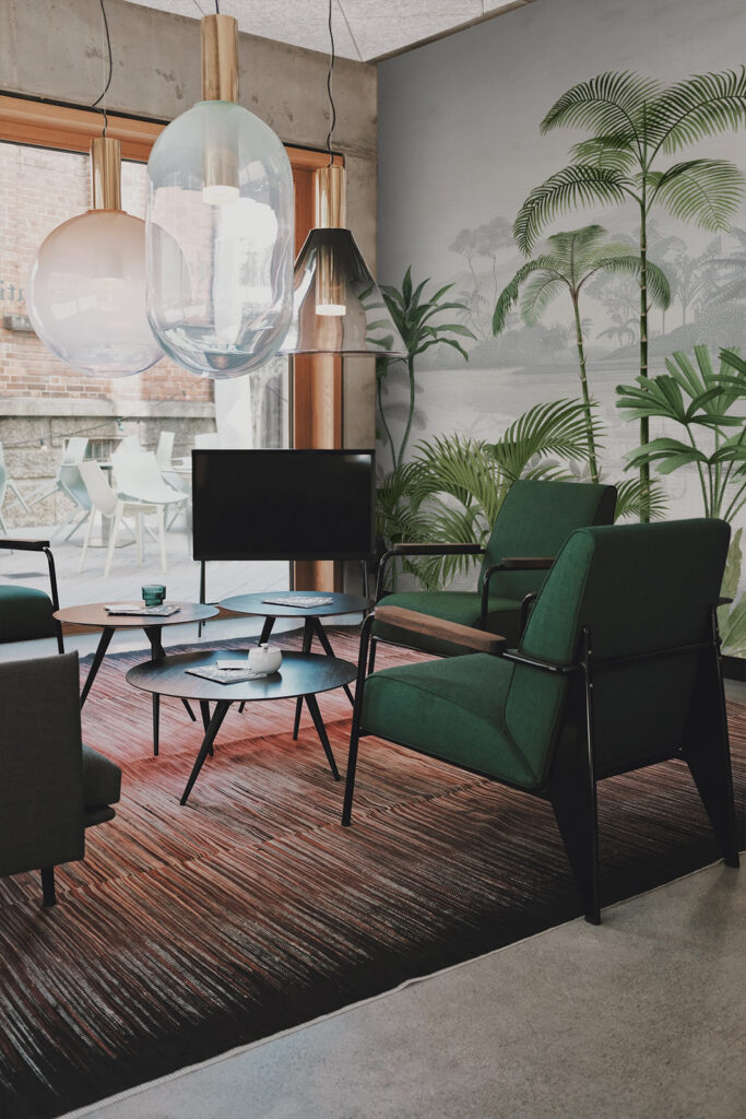 Living room wallpaper in tropical style. Jungle scene panoramic mural wallpaper paired with green furniture. Baubauwall Wallpapers
