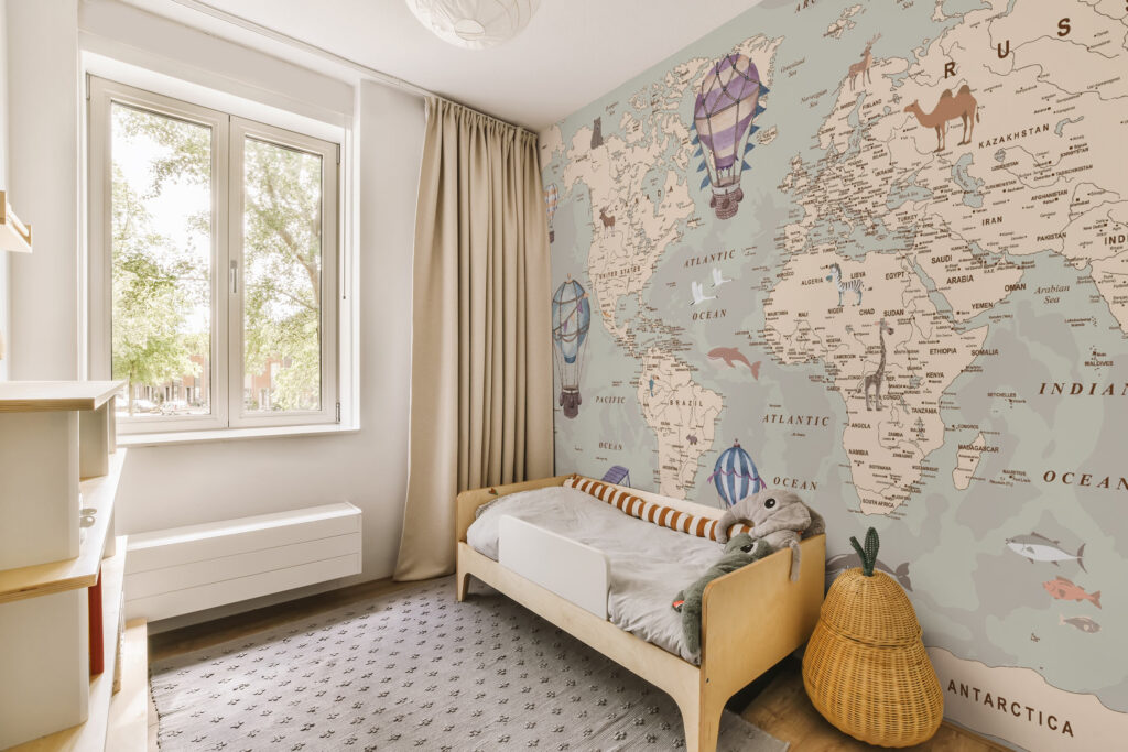 A vintage world map wallpaper for kids featuring animals, oceans and hot-air balloons in soft, muted colours. Custom-made to fit your wall. Baubauwall Tapeedid